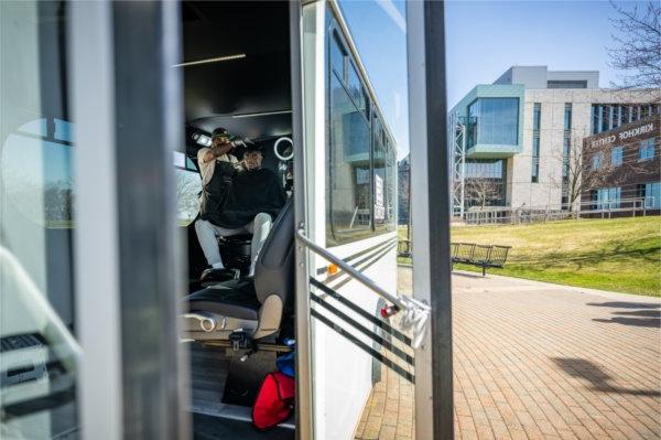Cecil Jackson cuts Charles Asamoah's hair in his barber van parked near the Cook Carillon Tower on the Allendale Campus.