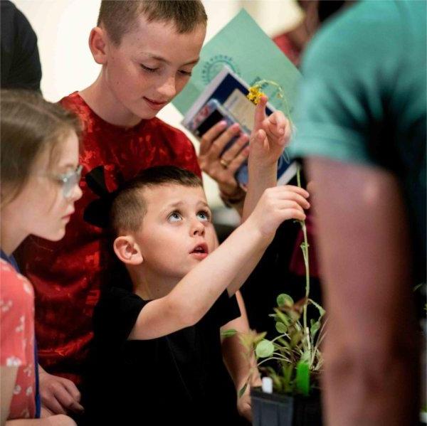 凯伦穆帅, 4, 5月15日，在皮尤大急流城校园举行的风潮管理倡议学生项目展示会上，他和家人在探索学生项目时检查了一棵植物.