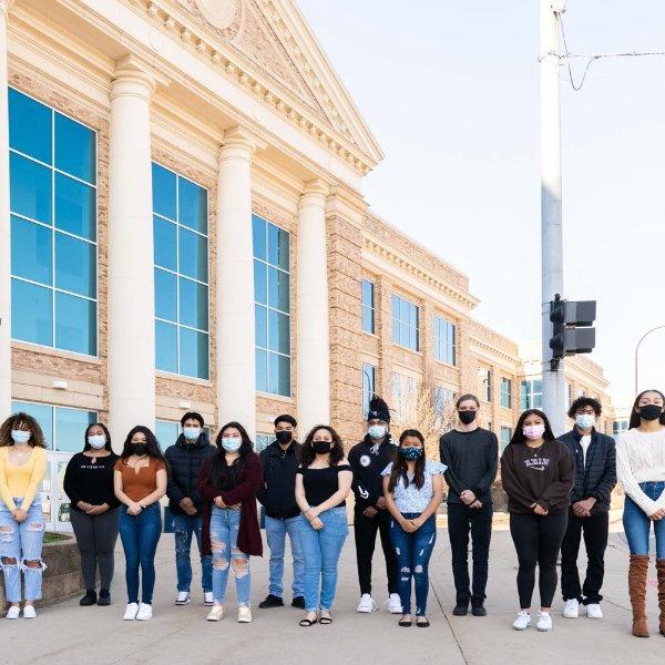 一群戴着面具的高中生在巴特克里克中心高中外站成一排