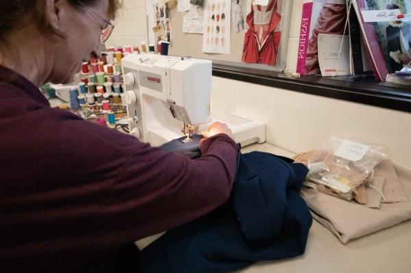 一个人正在缝纫机上缝制布料.