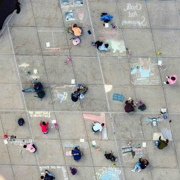 Aerial view from a drone of students participating in Chalk Art Symposium