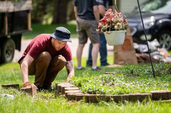 A volunteer from GVSU helps spruce up the yard of a local military veteran.