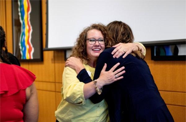 Leslie Bond Strychar, right, hugs fellow entrepreneur  Barbra Katerberg, left, 5月13日，在塞德曼中心举行的密歇根资深企业家实验室决赛中，两人都获得了现金奖励.