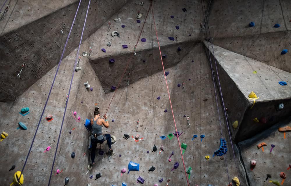一个人在大峡谷的艾伦代尔校区使用攀岩墙.