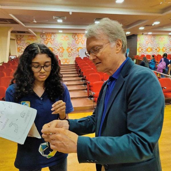 Mark Staves shows a dna piece of paper to a student in a classroom in India