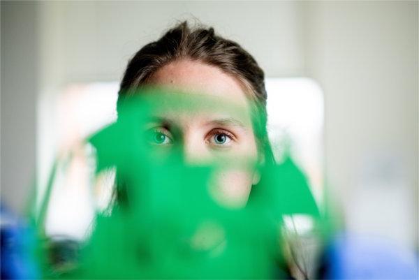 Kathryn Geller peers through one of the discs she designed and produced with a 3-D printer.