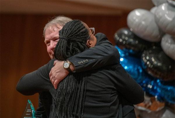 Andy Beachnau, assistant vice president for Student Affairs, hugs Nykia Gaines, assistant vice president for Federal TRIO programs, left, after Gaines presented Beachnau with an appreciation award during the event.