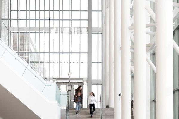 two women walk down steps at Mary Idema Pew Library